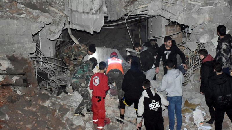 Rescuers search for survivors under the rubble of a damaged building, after Israeli missiles struck a number of sites in Syria's Homs province, according to state media, Syria February 7, 2024. SANA/Handout via REUTERS     ATTENTION EDITORS - THIS IMAGE WAS PROVIDED BY A THIRD PARTY. REUTERS IS UNABLE TO INDEPENDENTLY VERIFY THIS IMAGE.