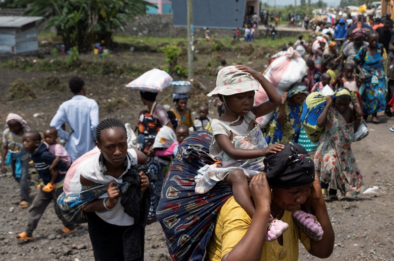 Warga membawa barang-barang saat mengunungsi menuju kota Goma di Republik Demokratik Kongo, Rabu (7/2/2024). (REUTERS/Arlette Bashizi)