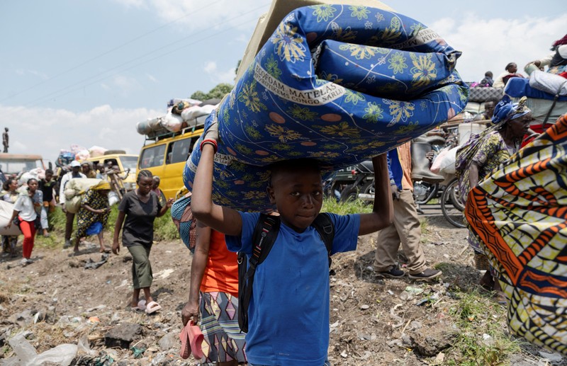 Warga membawa barang-barang saat mengunungsi menuju kota Goma di Republik Demokratik Kongo, Rabu (7/2/2024). (REUTERS/Arlette Bashizi)