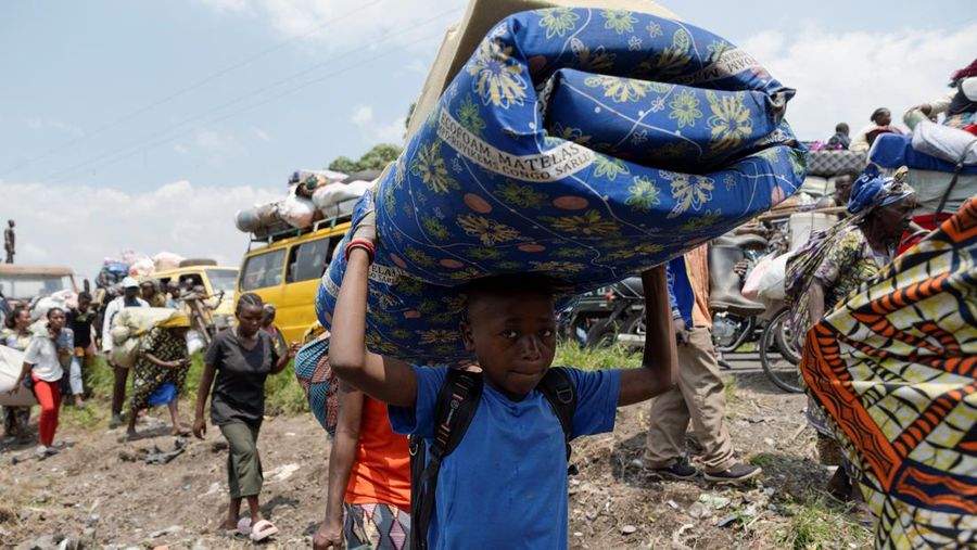 Warga membawa barang-barang saat mengunungsi menuju kota Goma di Republik Demokratik Kongo, Rabu (7/2/2024). (REUTERS/Arlette Bashizi)
