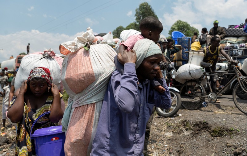 Warga membawa barang-barang saat mengunungsi menuju kota Goma di Republik Demokratik Kongo, Rabu (7/2/2024). (REUTERS/Arlette Bashizi)