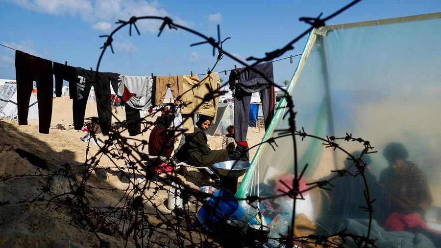Anggota keluarga Abu Mustafa Palestina yang mengungsi, yang meninggalkan rumah mereka akibat serangan Israel, berlindung di perbatasan dengan Mesir, di Rafah di selatan Jalur Gaza, 10 Februari 2024. (REUTERS/Mohammed Salem)