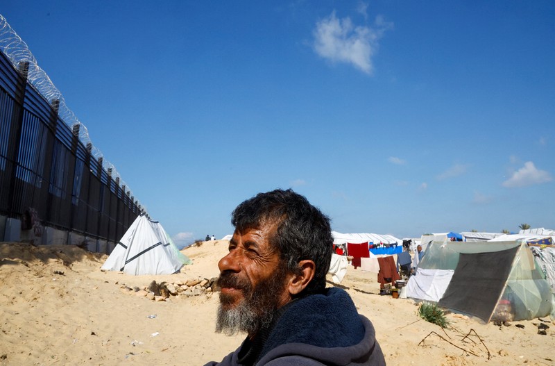 Pengungsi Palestina, Nasser Abu Mustafa, yang meninggalkan rumahnya akibat serangan Israel, melihat saat ia berlindung di perbatasan dengan Mesir, di Rafah di selatan Jalur Gaza, 10 Februari 2024. Pengungsi Palestina, Nasser Abu Mustafa, yang meninggalkan rumahnya akibat serangan Israel, melihat saat ia berlindung di perbatasan dengan Mesir, di Rafah di selatan Jalur Gaza, 10 Februari 2024. (REUTERS/Mohammed Salem)