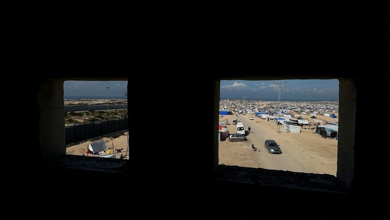Pengungsi Palestina, Nasser Abu Mustafa, yang meninggalkan rumahnya akibat serangan Israel, melihat saat ia berlindung di perbatasan dengan Mesir, di Rafah di selatan Jalur Gaza, 10 Februari 2024. (REUTERS/Mohammed Salem)
