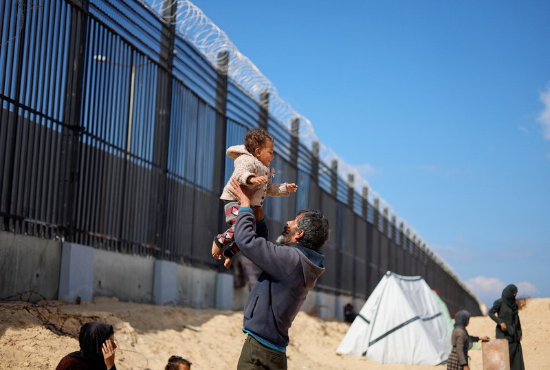Pengungsi Palestina, Nasser Abu Mustafa, yang meninggalkan rumahnya akibat serangan Israel, melihat saat ia berlindung di perbatasan dengan Mesir, di Rafah di selatan Jalur Gaza, 10 Februari 2024. (REUTERS/Mohammed Salem)