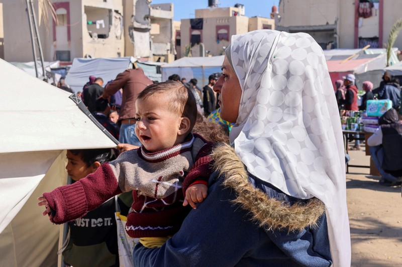 Pengungsi Palestina, Nasser Abu Mustafa, yang meninggalkan rumahnya akibat serangan Israel, melihat saat ia berlindung di perbatasan dengan Mesir, di Rafah di selatan Jalur Gaza, 10 Februari 2024. (REUTERS/Mohammed Salem)