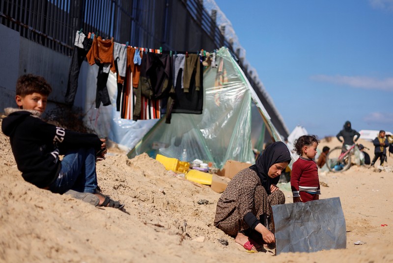 Pengungsi Palestina, Nasser Abu Mustafa, yang meninggalkan rumahnya akibat serangan Israel, melihat saat ia berlindung di perbatasan dengan Mesir, di Rafah di selatan Jalur Gaza, 10 Februari 2024. (REUTERS/Mohammed Salem)