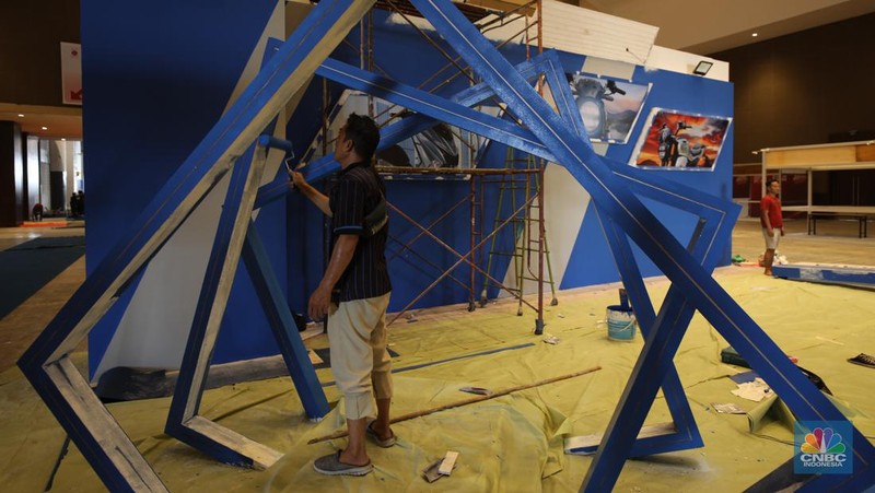 Aktivitas para pekerja mempersiapkan stan peserta pameran otomotif Indonesia International Motor Show (IIMS) 2024 di JIExpo Kemayoran, Jakarta, Selasa (13/2/2024). Pameran otomotif ini berlangsung pada tanggal 15-25 Februari 2024. (CNBC Indonesia/Tri Susilo)