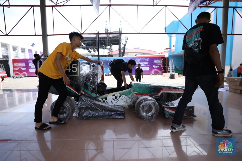 Aktivitas para pekerja mempersiapkan stan peserta pameran otomotif Indonesia International Motor Show (IIMS) 2024 di JIExpo Kemayoran, Jakarta, Selasa (13/2/2024). Pameran otomotif ini berlangsung pada tanggal 15-25 Februari 2024. (CNBC Indonesia/Tri Susilo)