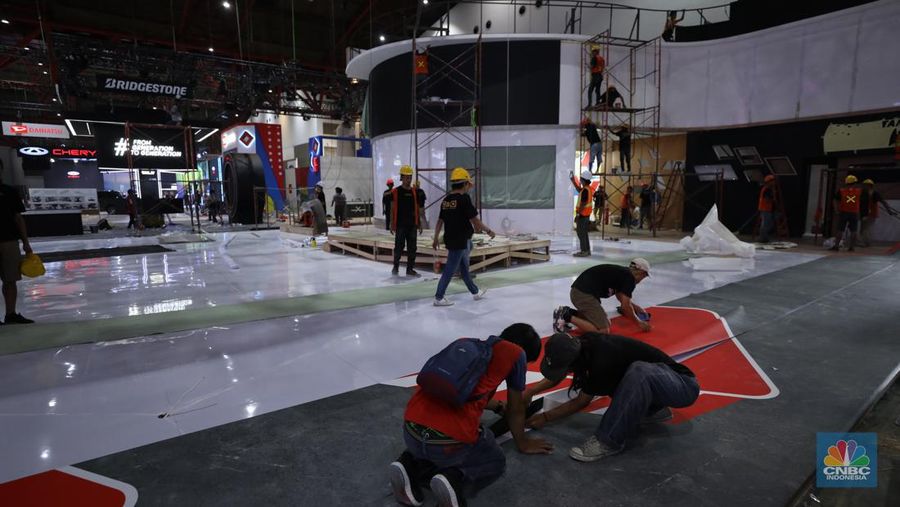 Aktivitas para pekerja mempersiapkan stan peserta pameran otomotif Indonesia International Motor Show (IIMS) 2024 di JIExpo Kemayoran, Jakarta, Selasa (13/2/2024). Pameran otomotif ini berlangsung pada tanggal 15-25 Februari 2024. (CNBC Indonesia/Tri Susilo)