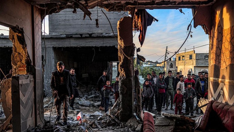 People inspect debris and rubble in a building heavily damaged by Israeli bombardment, in Rafah in the southern Gaza Strip on February 11, 2024, amid the ongoing conflict between Israel and the Palestinian militant group Hamas. (Photo by SAID KHATIB / AFP)