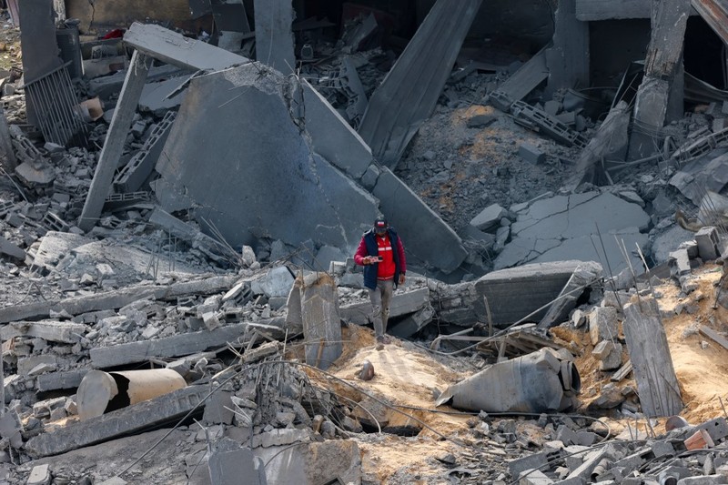 People inspect debris and rubble in a building heavily damaged by Israeli bombardment, in Rafah in the southern Gaza Strip on February 11, 2024, amid the ongoing conflict between Israel and the Palestinian militant group Hamas. (Photo by SAID KHATIB / AFP)