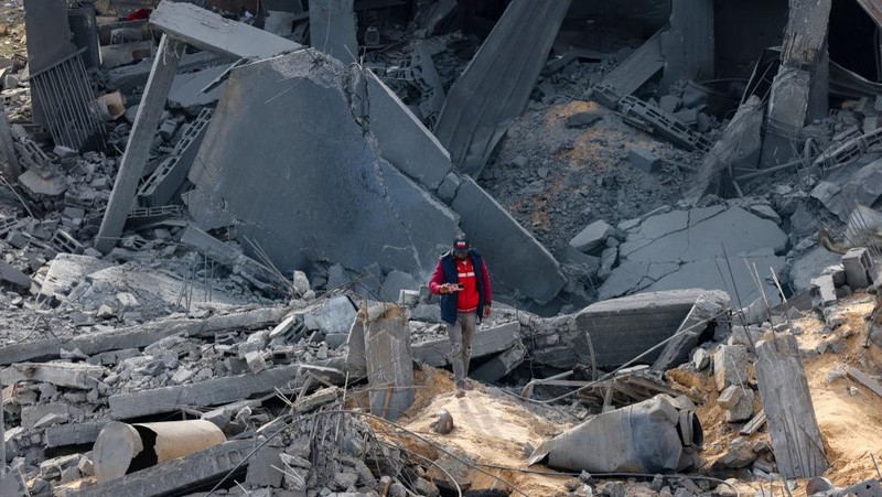 People inspect debris and rubble in a building heavily damaged by Israeli bombardment, in Rafah in the southern Gaza Strip on February 11, 2024, amid the ongoing conflict between Israel and the Palestinian militant group Hamas. (Photo by SAID KHATIB / AFP)
