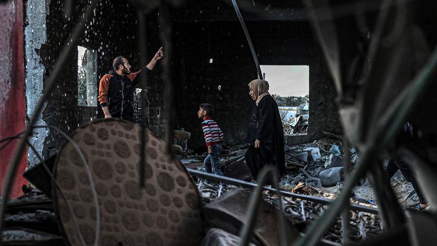 People inspect debris and rubble in a building heavily damaged by Israeli bombardment, in Rafah in the southern Gaza Strip on February 11, 2024, amid the ongoing conflict between Israel and the Palestinian militant group Hamas. (Photo by SAID KHATIB / AFP)
