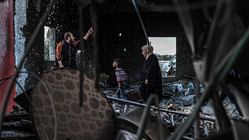 People inspect debris and rubble in a building heavily damaged by Israeli bombardment, in Rafah in the southern Gaza Strip on February 11, 2024, amid the ongoing conflict between Israel and the Palestinian militant group Hamas. (Photo by SAID KHATIB / AFP)