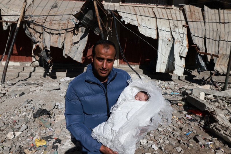 PALESTINIAN-ISRAEL-CONFLICT People inspect debris and rubble in a building heavily damaged by Israeli bombardment, in Rafah in the southern Gaza Strip on February 11, 2024, amid the ongoing conflict between Israel and the Palestinian militant group Hamas. (Photo by SAID KHATIB / AFP)
