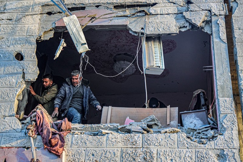 PALESTINIAN-ISRAEL-CONFLICT People inspect debris and rubble in a building heavily damaged by Israeli bombardment, in Rafah in the southern Gaza Strip on February 11, 2024, amid the ongoing conflict between Israel and the Palestinian militant group Hamas. (Photo by SAID KHATIB / AFP)