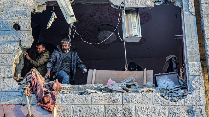 People inspect debris and rubble in a building heavily damaged by Israeli bombardment, in Rafah in the southern Gaza Strip on February 11, 2024, amid the ongoing conflict between Israel and the Palestinian militant group Hamas. (Photo by SAID KHATIB / AFP)