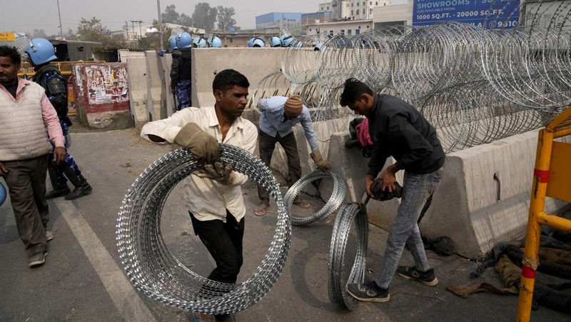 Personel Pasukan Aksi Cepat menjaga jalan raya utama di Singhu dekat New Delhi untuk menghentikan ribuan petani yang melakukan protes memasuki ibu kota, India, Selasa, 13 Februari 2024. Para petani, yang memulai demonstrasi mereka dari negara bagian Haryana utara dan Punjab, meminta agar jaminan harga dukungan minimum untuk semua produk pertanian. (AP Photo/Manish Swarup)