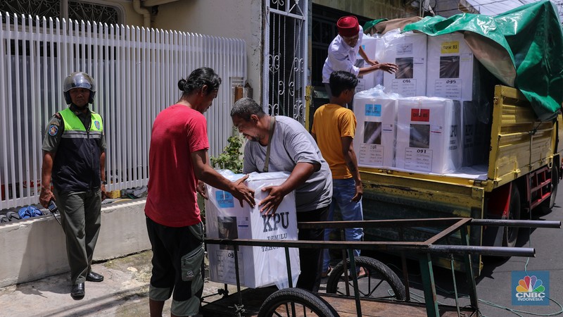 Petugas membawa kotak suara saat pendistribusian logistik Pemilu 2024 pada salah satu pemukiman padat RW 08 di Kelurahan Petamburan, Jakarta, Selasa (13/2/2024). (CNBC Indonesia/Faisal Rahman)