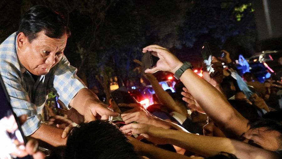 Calon presiden Indonesia Prabowo Subianto didampingi calon wakil presiden Indonesia Gibran Rakabuming Raka, menyapa pendukungnya dari atas mobil menuju Istora Senayan, pada Rabu (14/2/2024). (REUTERS/Ajeng Dinar Ulfiana)