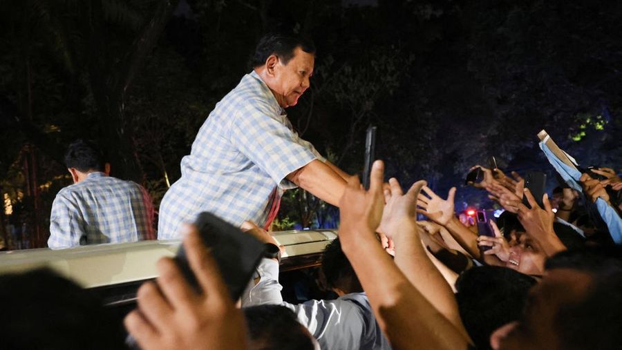 Calon presiden Indonesia Prabowo Subianto didampingi calon wakil presiden Indonesia Gibran Rakabuming Raka, menyapa pendukungnya dari atas mobil menuju Istora Senayan, pada Rabu (14/2/2024). (REUTERS/Ajeng Dinar Ulfiana)