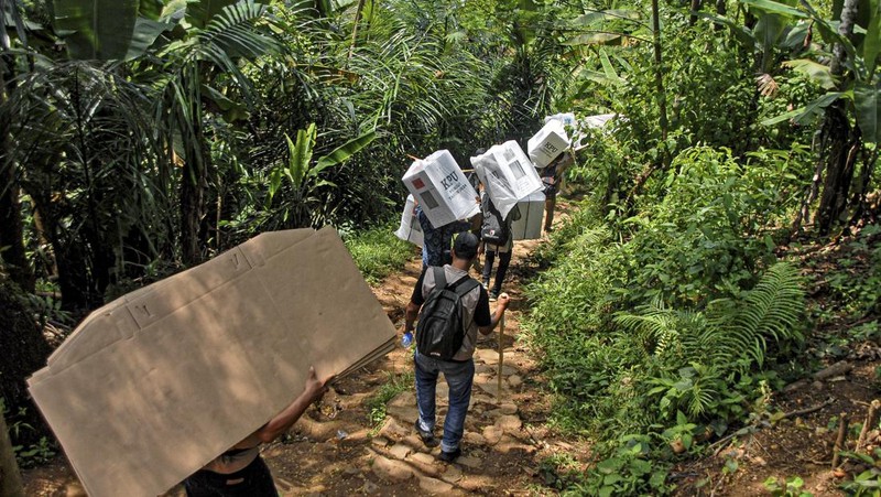 Warga suku Baduy membawa kotak suara untuk didistribusikan ke TPS menjelang pemilu 14 Februari, di desa Kanekes, Banten, Selasa, 13 Februari 2024. (AP Photo/Rangga Firmansyah)
