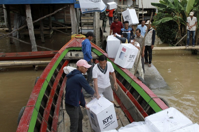 Warga suku Baduy membawa kotak suara untuk didistribusikan ke TPS menjelang pemilu 14 Februari, di desa Kanekes, Banten, Selasa, 13 Februari 2024. (AP Photo/Rangga Firmansyah)