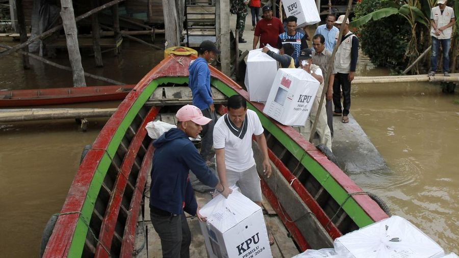 Warga suku Baduy membawa kotak suara untuk didistribusikan ke TPS menjelang pemilu 14 Februari, di desa Kanekes, Banten, Selasa, 13 Februari 2024. (AP Photo/Rangga Firmansyah)