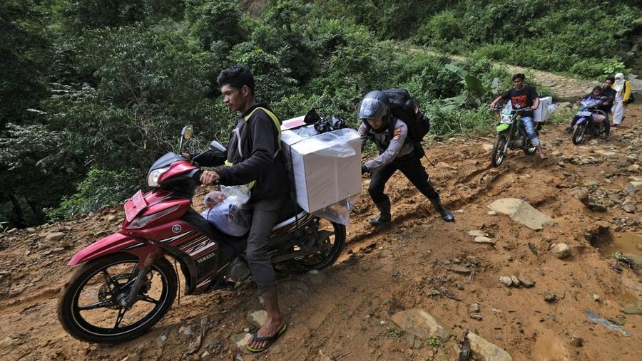 Warga suku Baduy membawa kotak suara untuk didistribusikan ke TPS menjelang pemilu 14 Februari, di desa Kanekes, Banten, Selasa, 13 Februari 2024. (AP Photo/Rangga Firmansyah)
