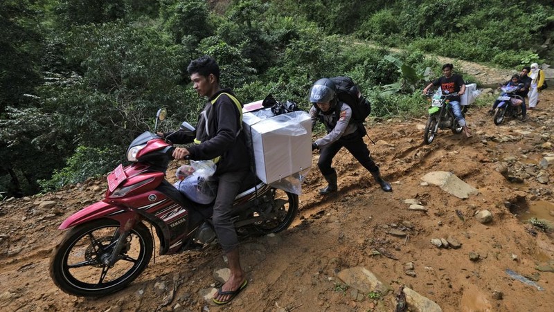 Warga suku Baduy membawa kotak suara untuk didistribusikan ke TPS menjelang pemilu 14 Februari, di desa Kanekes, Banten, Selasa, 13 Februari 2024. (AP Photo/Rangga Firmansyah)