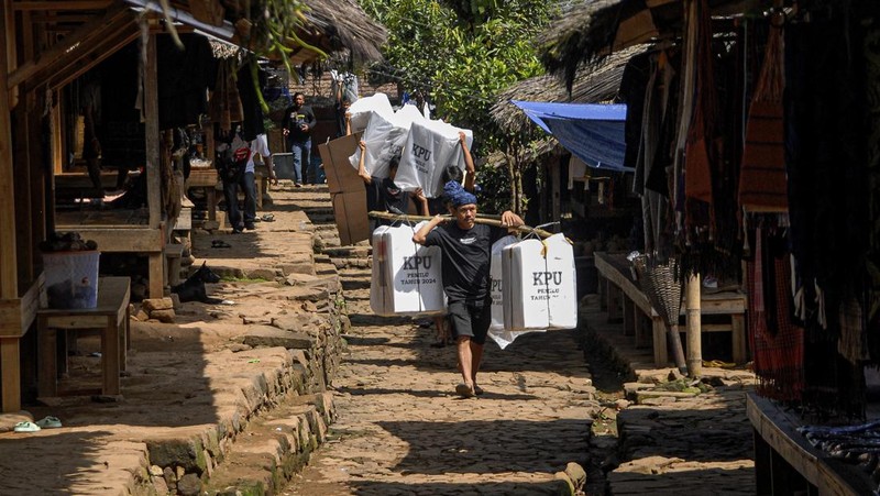 Warga suku Baduy membawa kotak suara untuk didistribusikan ke TPS menjelang pemilu 14 Februari, di desa Kanekes, Banten, Selasa, 13 Februari 2024. (AP Photo/Rangga Firmansyah)