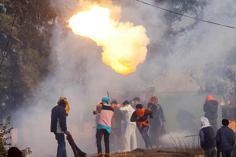 Para petani, yang berbaris menuju New Delhi untuk menuntut harga tanaman yang lebih baik yang dijanjikan kepada mereka pada tahun 2021, melemparkan gas air mata kembali ke arah polisi, di Shambhu, perbatasan antara negara bagian Punjab dan Haryana, India, 14 Februari 2024. (REUTERS/Anushree Fadnavis)
