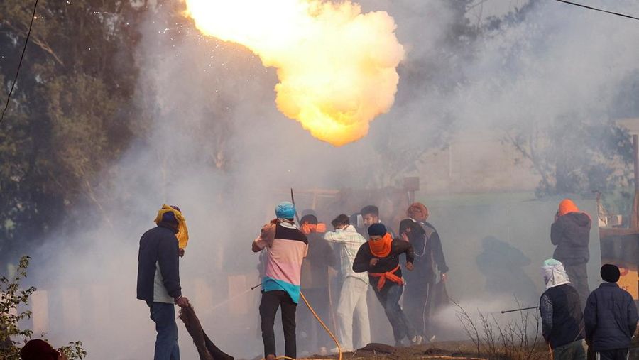 Para petani, yang berbaris menuju New Delhi untuk menuntut harga tanaman yang lebih baik yang dijanjikan kepada mereka pada tahun 2021, melemparkan gas air mata kembali ke arah polisi, di Shambhu, perbatasan antara negara bagian Punjab dan Haryana, India, 14 Februari 2024. (REUTERS/Anushree Fadnavis)