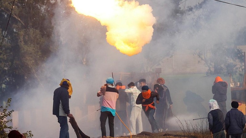 Para petani, yang berbaris menuju New Delhi untuk menuntut harga tanaman yang lebih baik yang dijanjikan kepada mereka pada tahun 2021, melemparkan gas air mata kembali ke arah polisi, di Shambhu, perbatasan antara negara bagian Punjab dan Haryana, India, 14 Februari 2024. (REUTERS/Anushree Fadnavis)