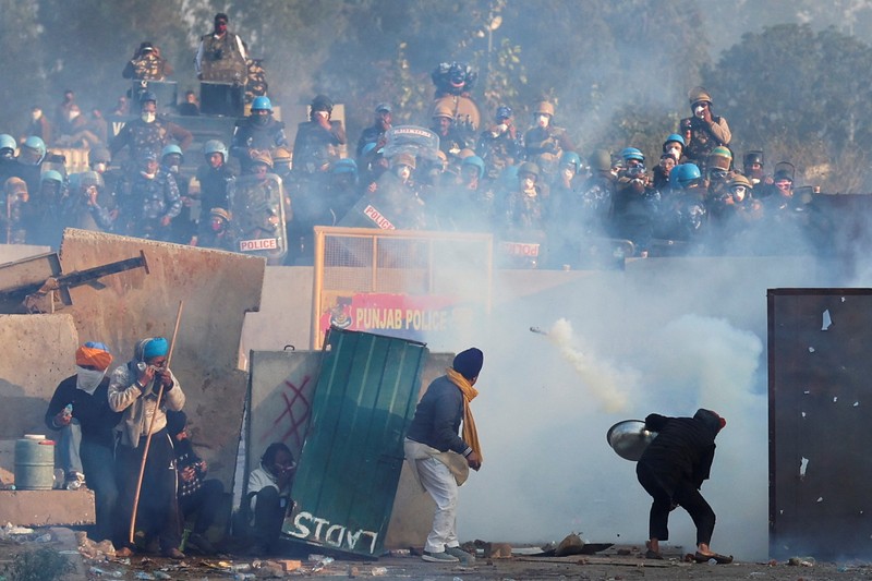 Para petani, yang berbaris menuju New Delhi untuk menuntut harga tanaman yang lebih baik yang dijanjikan kepada mereka pada tahun 2021, melemparkan gas air mata kembali ke arah polisi, di Shambhu, perbatasan antara negara bagian Punjab dan Haryana, India, 14 Februari 2024. (REUTERS/Anushree Fadnavis)