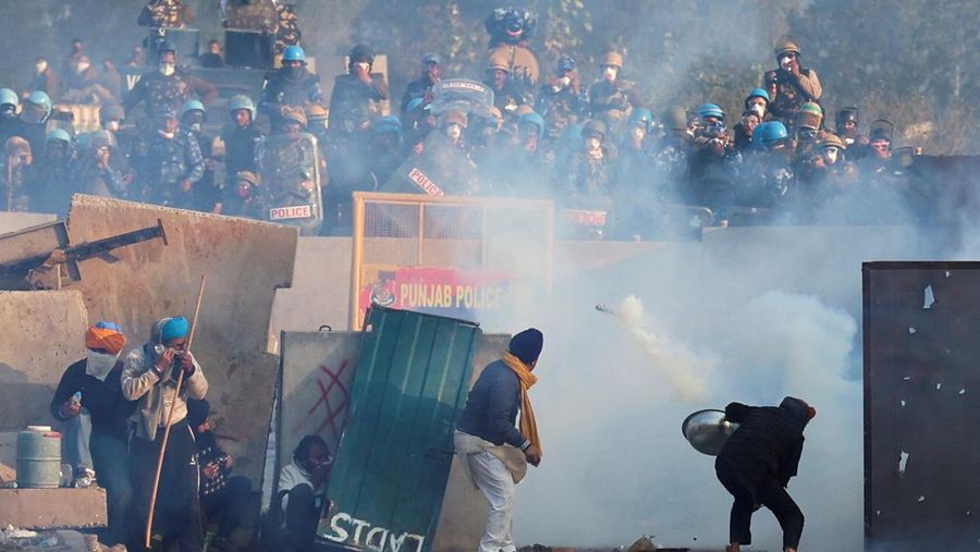 Para petani, yang berbaris menuju New Delhi untuk menuntut harga tanaman yang lebih baik yang dijanjikan kepada mereka pada tahun 2021, melemparkan gas air mata kembali ke arah polisi, di Shambhu, perbatasan antara negara bagian Punjab dan Haryana, India, 14 Februari 2024. (REUTERS/Anushree Fadnavis)