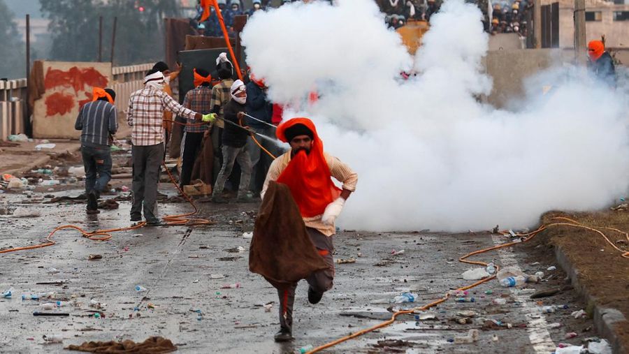 Para petani, yang berbaris menuju New Delhi untuk menuntut harga tanaman yang lebih baik yang dijanjikan kepada mereka pada tahun 2021, melemparkan gas air mata kembali ke arah polisi, di Shambhu, perbatasan antara negara bagian Punjab dan Haryana, India, 14 Februari 2024. (REUTERS/Anushree Fadnavis)