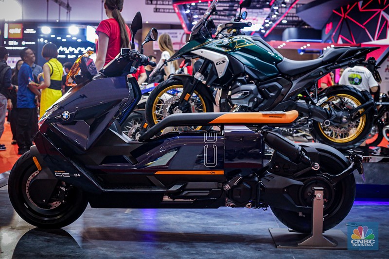 Sejumlah pengunjung melihat motor listrik BMW CE-04 di booth BMW Motorrad dalam ajang Indonesia International Motor Show (IIMS 2024) pada Minggu, (17/2/2024). (CNBC Indonesia/Tias Budiarto)