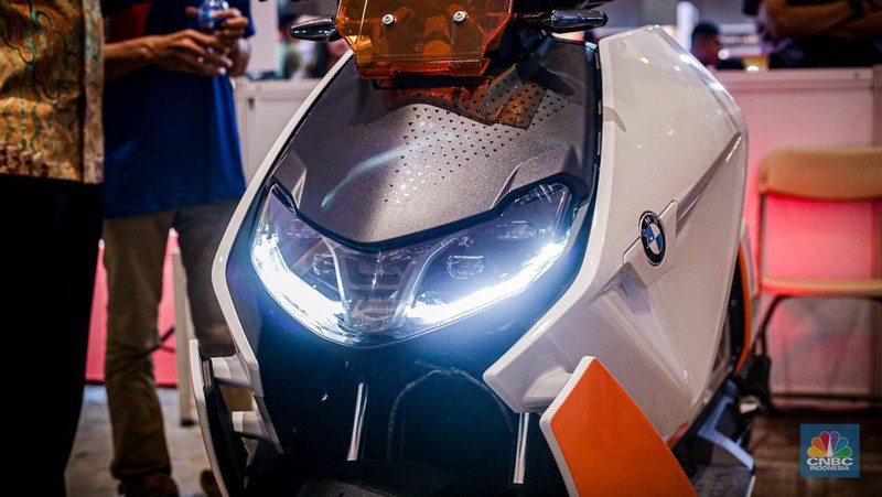 Sejumlah pengunjung melihat motor listrik BMW CE-04 di booth BMW Motorrad dalam ajang Indonesia International Motor Show (IIMS 2024) pada Minggu, (17/2/2024). (CNBC Indonesia/Tias Budiarto)