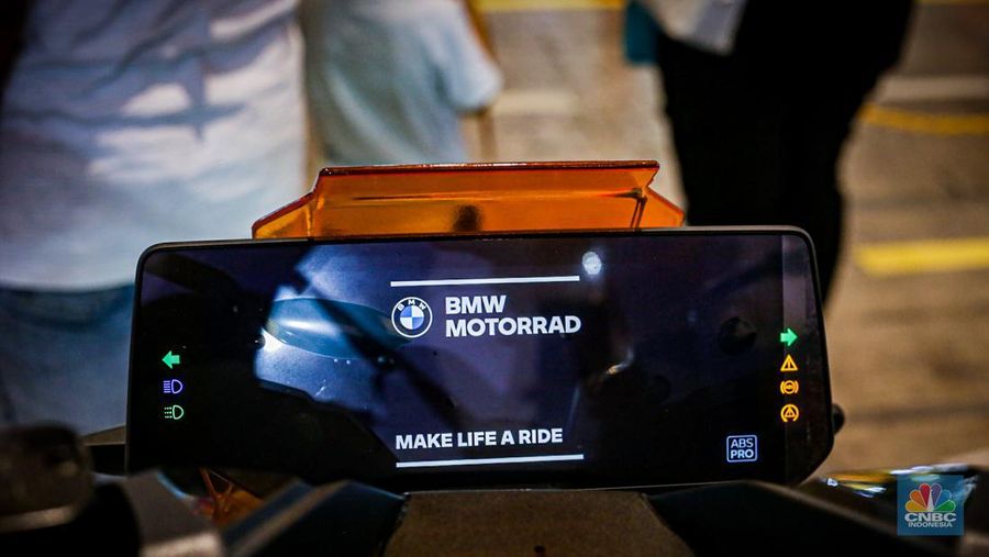 Sejumlah pengunjung melihat motor listrik BMW CE-04 di booth BMW Motorrad dalam ajang Indonesia International Motor Show (IIMS 2024) pada Minggu, (17/2/2024). (CNBC Indonesia/Tias Budiarto)