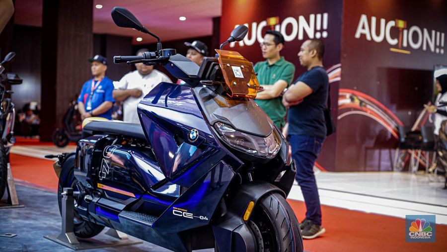Sejumlah pengunjung melihat motor listrik BMW CE-04 di booth BMW Motorrad dalam ajang Indonesia International Motor Show (IIMS 2024) pada Minggu, (17/2/2024). (CNBC Indonesia/Tias Budiarto)