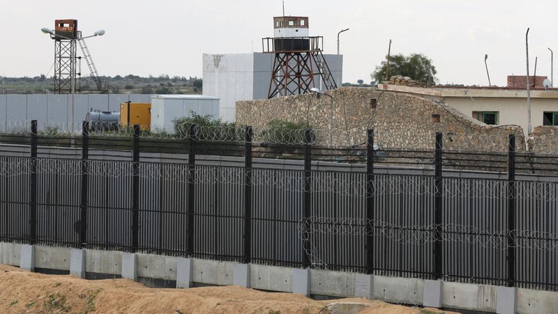 Pengungsi Palestina, yang meninggalkan rumah mereka karena serangan Israel, di tengah konflik yang sedang berlangsung antara Israel dan kelompok Islam Palestina Hamas, duduk di luar tenda di perbatasan dengan Mesir, di tengah kekhawatiran akan serangan darat Israel di Rafah, di Jalur Gaza selatan 18 Februari 2024. REUTERS/Saleh Salem