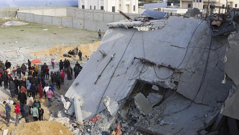 Warga Palestina melihat kehancuran pasca serangan Israel terhadap sebuah bangunan tempat tinggal di Rafah, Jalur Gaza, Jumat, 16 Februari 2024.
