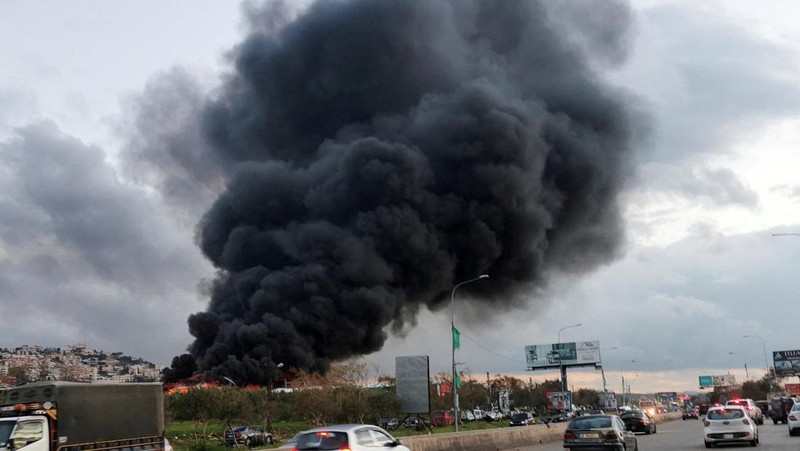 Asap hitam dan api membubung dari gudang yang terbakar, diserang oleh serangan Israel, di kawasan industri, di kota pesisir selatan Ghazieh, Lebanon, Senin, 19 Februari 2024. Angkatan udara Israel melakukan setidaknya dua serangan udara di dekat wilayah selatan kota pelabuhan Sidon dalam salah satu serangan terbesar di dekat kota besar, media pemerintah melaporkan. (AP Photo/Mohammed Zaatari)