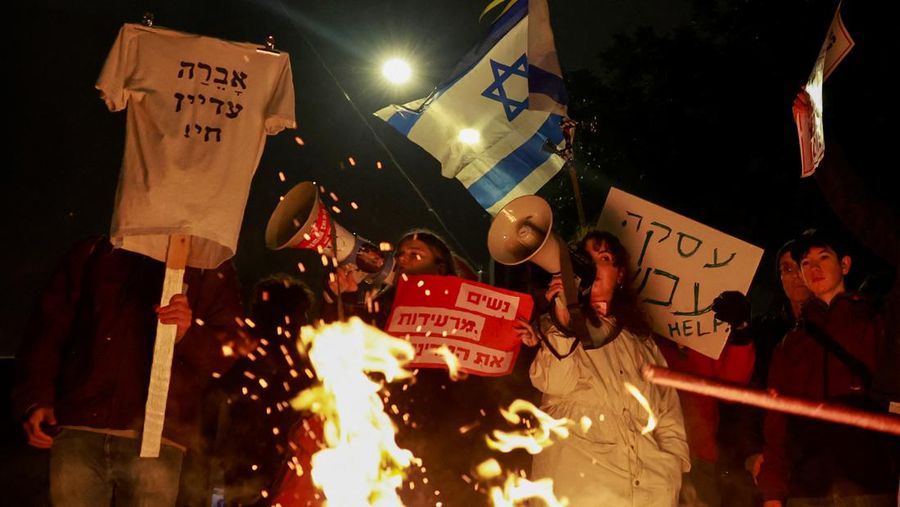 Orang-orang melakukan protes di dekat api unggun, saat mereka berjalan menuju kediaman Perdana Menteri Israel Benjamin Netanyahu, saat melakukan protes terhadap pemerintah Israel, di tengah konflik yang sedang berlangsung antara Israel dan kelompok Islam Palestina Hamas, di Yerusalem, 19 Februari 2024. (REUTERS/Ammar Awad)