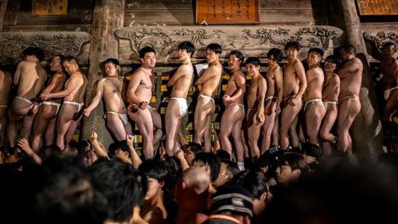 Para pria membersihkan tubuh mereka di sungai selama Festival Sominsai di Kuil Kokuseki-ji di Oshu, Prefektur Iwate, Jepang, pada 17 Februari 2024. (Photo by Philip FONG / AFP)