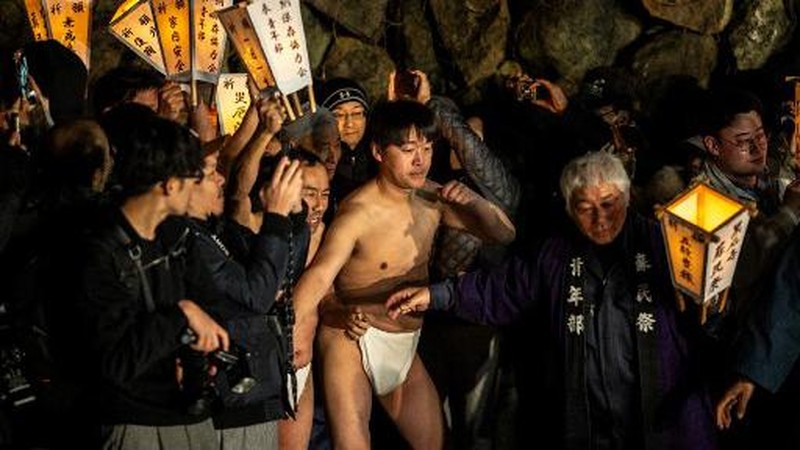 Para pria membersihkan tubuh mereka di sungai selama Festival Sominsai di Kuil Kokuseki-ji di Oshu, Prefektur Iwate, Jepang, pada 17 Februari 2024. (Photo by Philip FONG / AFP)