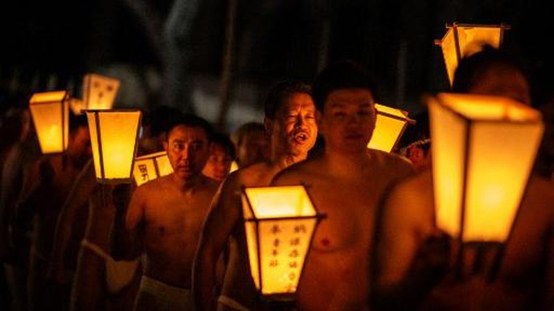 Para pria membersihkan tubuh mereka di sungai selama Festival Sominsai di Kuil Kokuseki-ji di Oshu, Prefektur Iwate, Jepang, pada 17 Februari 2024. (Photo by Philip FONG / AFP)