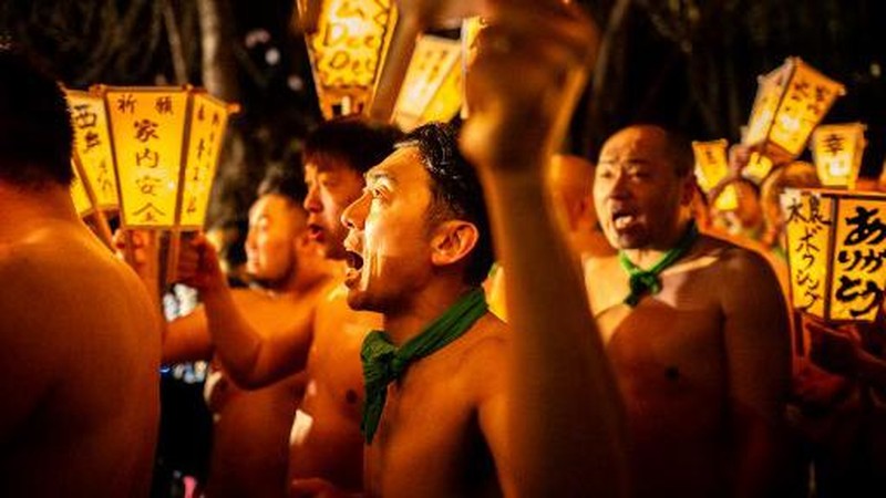 Para pria membersihkan tubuh mereka di sungai selama Festival Sominsai di Kuil Kokuseki-ji di Oshu, Prefektur Iwate, Jepang, pada 17 Februari 2024. (Photo by Philip FONG / AFP)